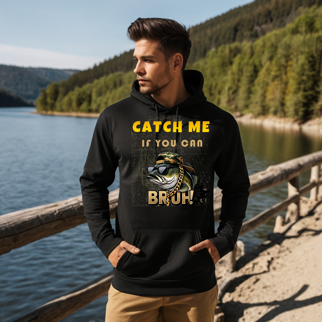 Man wearing a black hoodie with the text "Catch Me If You Can Bruh" featuring a cool fish graphic, standing near a river.