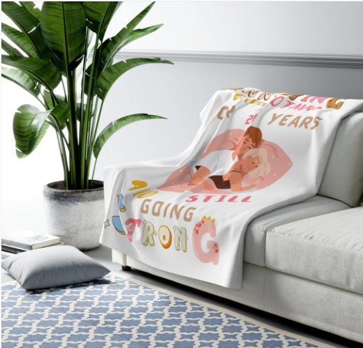 "Cozy personalized anniversary blanket draped over a sofa, featuring a cuddling couple with the humorous text 'Annoying each other for 123 years and still going strong' – customizable with names – perfect for couple gifts, home decor, and romantic throws – available at homeshopi.com.